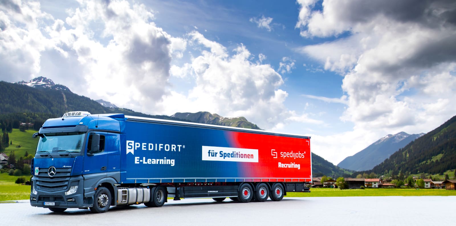 Spedition-LKW Seitenansicht in Alpenlandschaft